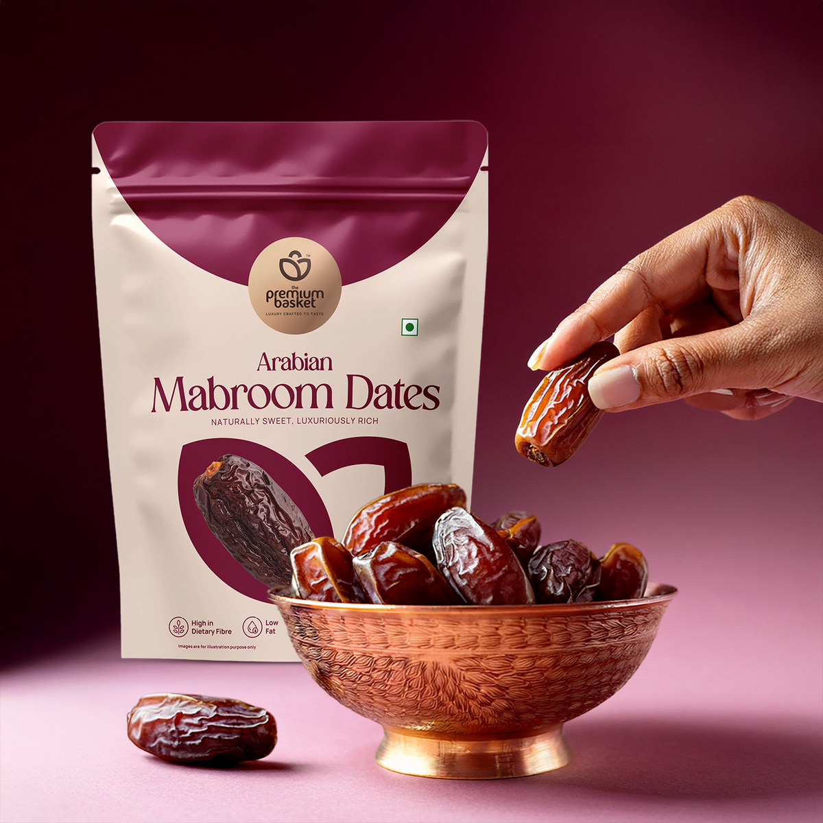 Arabian Mabroom Dates pouch with a bowl of dark dates and a hand holding one