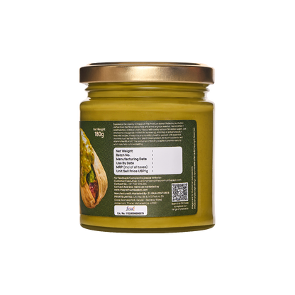 Pistachio nut butter jar with back label, green glass, and gold lid
